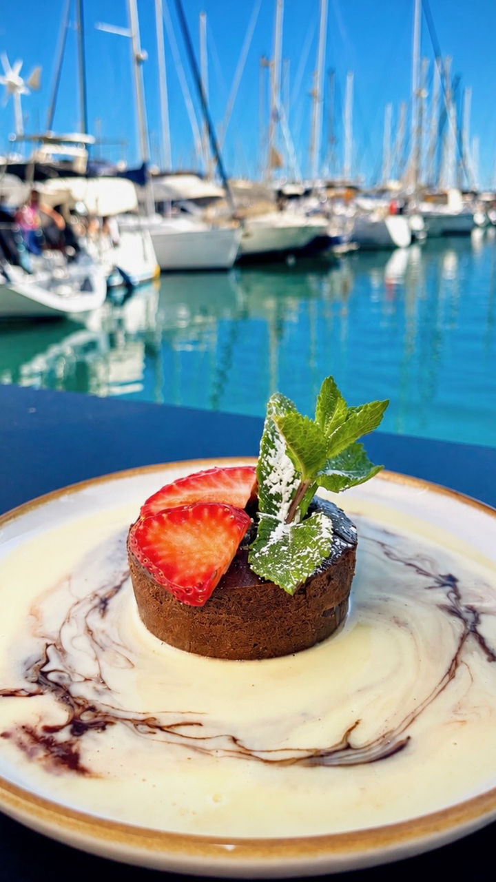 Dessert au chocolat avec fraises fraîches et menthe servi face au port du Cap d’Agde au Carré Rouge