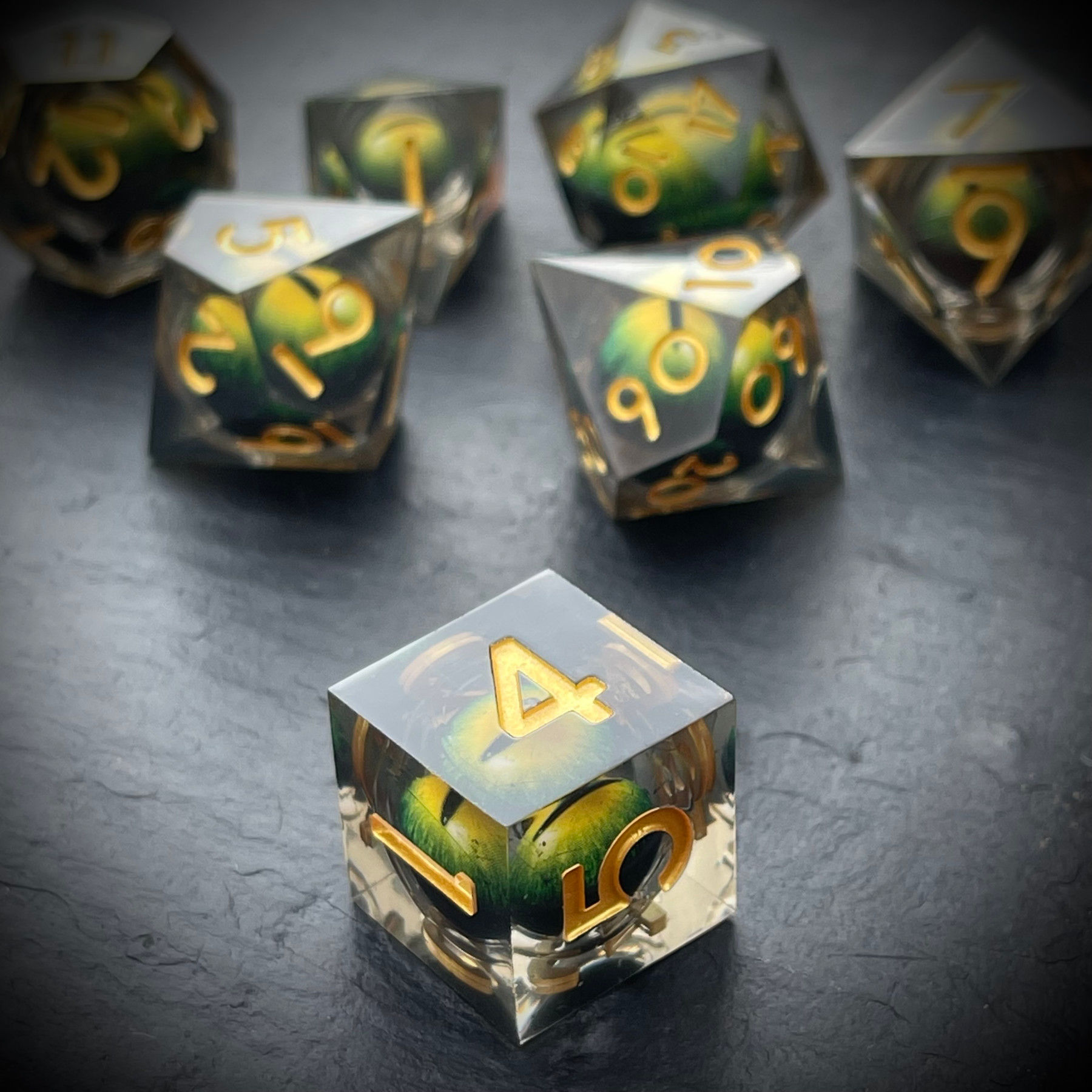 dé RPG transparent avec œil de dragon jaune flottant à l’intérieur