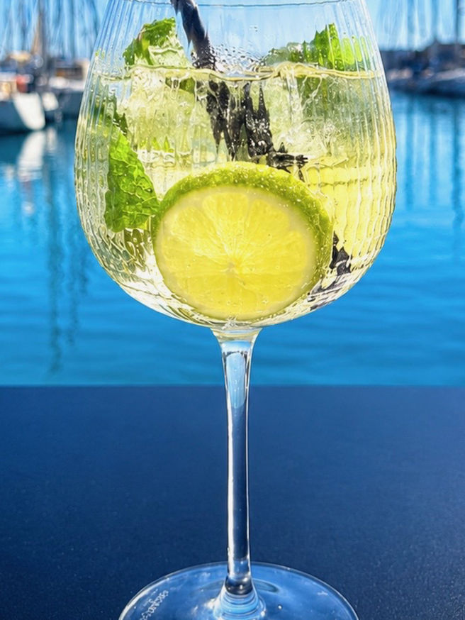Cocktail frais au citron vert et à la menthe servi face aux bateaux du port du Cap d’Agde au Carré Rouge