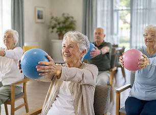 Personnes âgées participant à une séance d’activité douce assise avec ballons en EHPAD ou résidence seniors pour améliorer la mobilité et le bien-être.