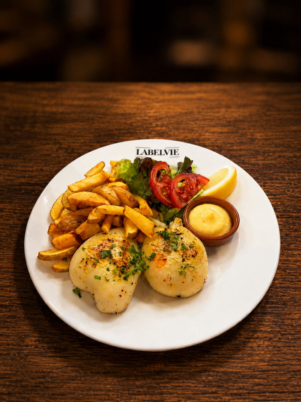 Assiette de seiche à la plancha avec frites maison, salade et sauce au restaurant Labelvie à Pomérols