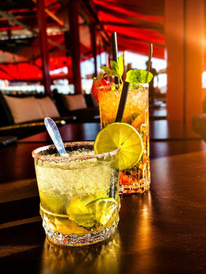 Deux cocktails colorés servis en terrasse dans l’ambiance chaleureuse du Carré Rouge au Cap d’Agde