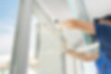 worker with a rubber mallet inserts a glass into the frame of a plastic window_edited.jpg