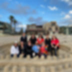 A group of women posing on a sand sculpture on Mission Beach
