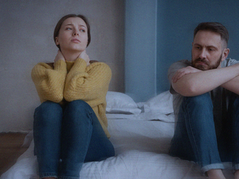 Paar sitzend und schweigend nebeneinander