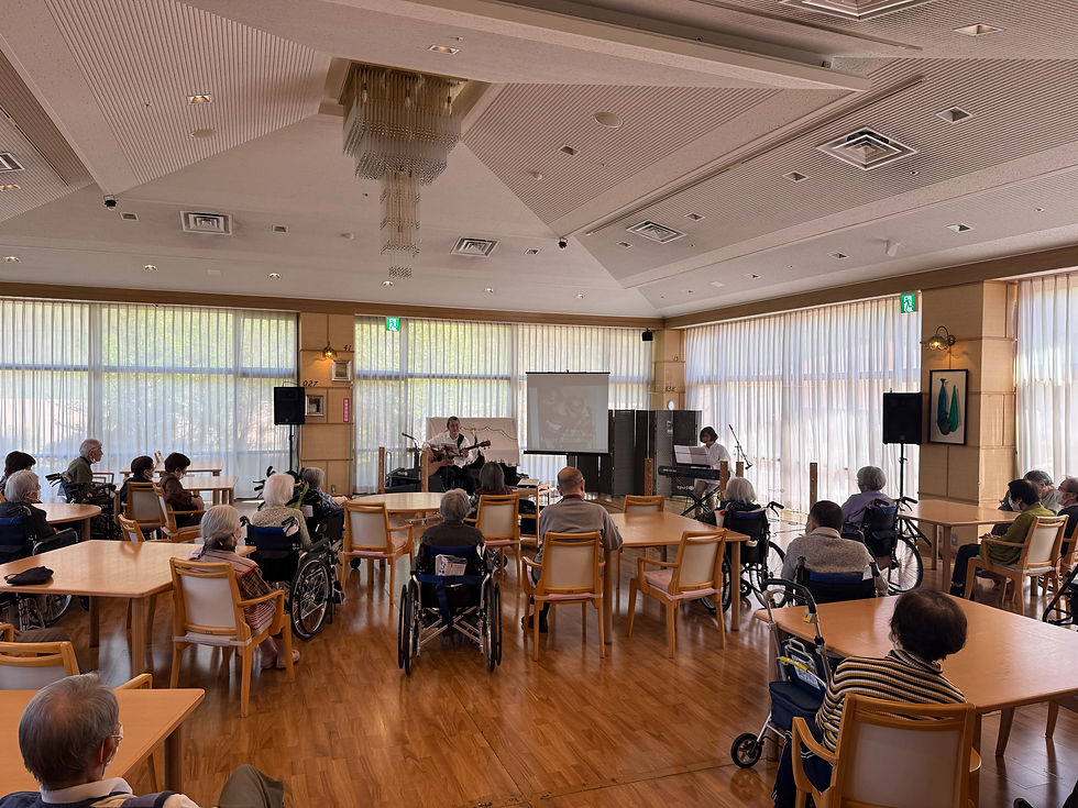 豪華なシャンデリアと大きな窓がある広々としたミソノピアのメインホール全体で、多くの入居者様がジャズ演奏を楽しんでいる様子