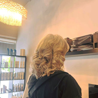 Blonde highlights and big bouncy curls by Ana senior colourist at Fluid3