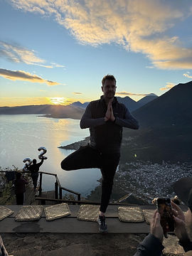 a person doing tree pose with lake atitlan in the background