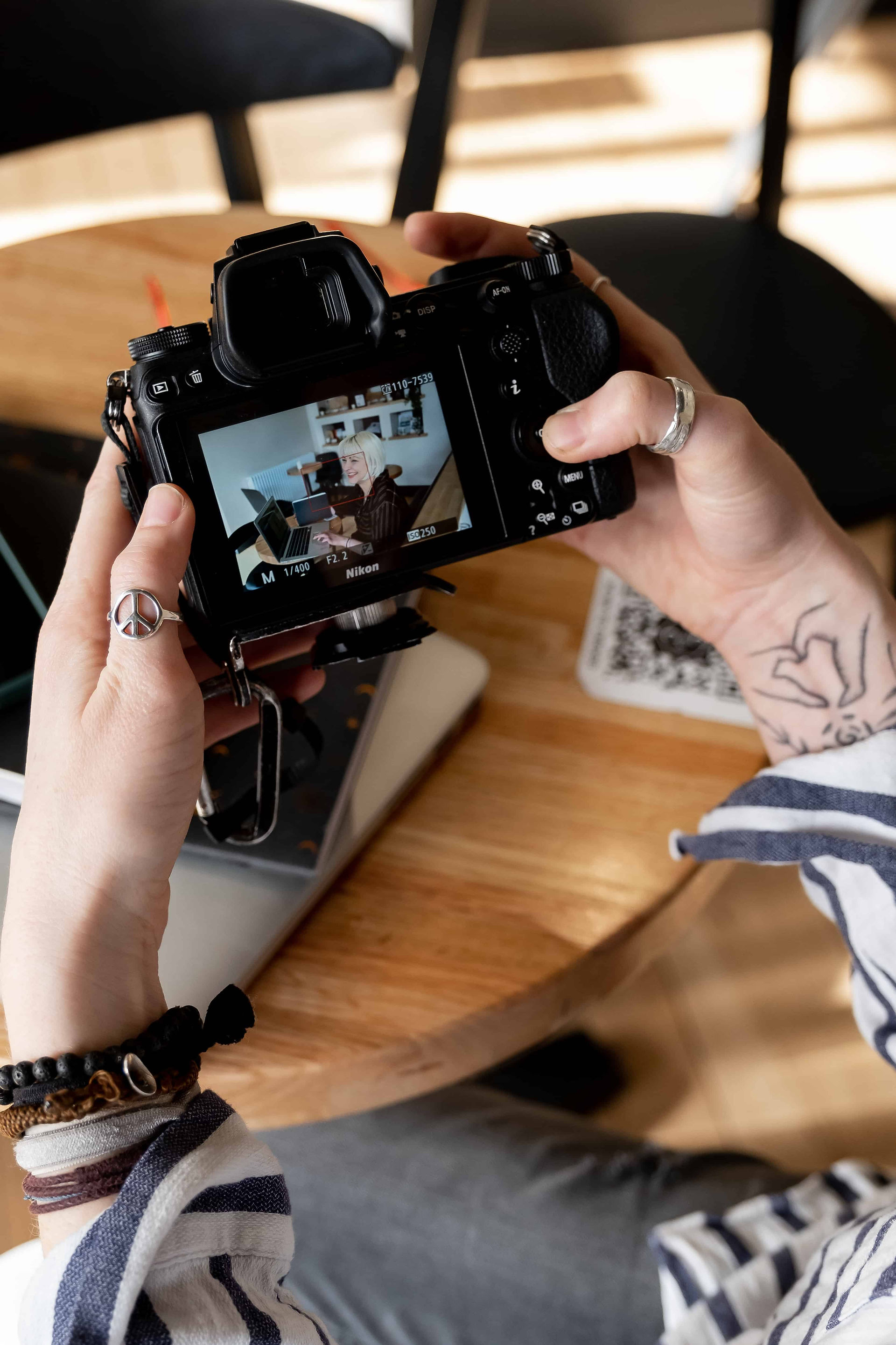 Up close image of woman holding a camera and looking at the photo on the back screen.