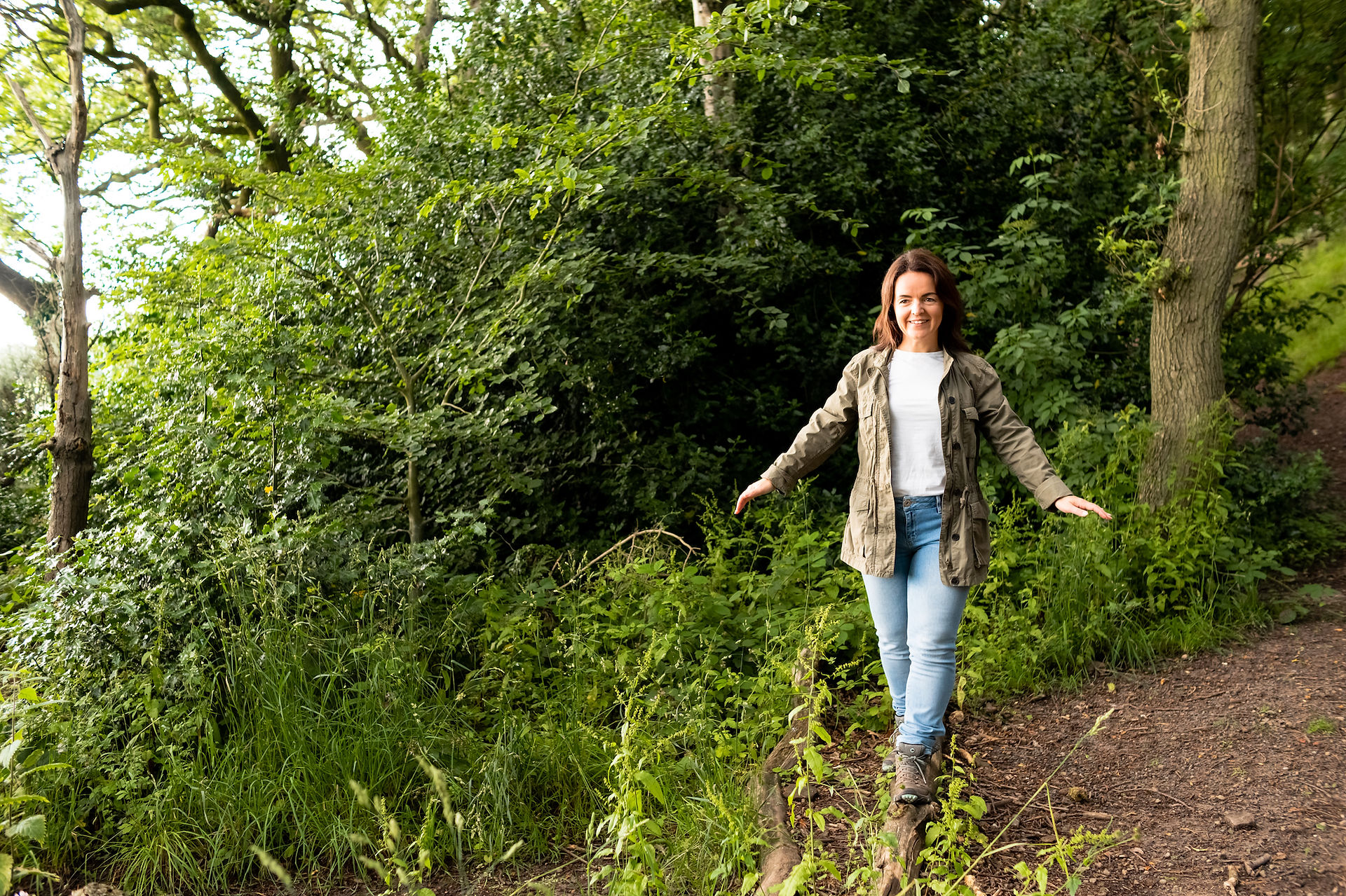 Woman walking in Wirral woods during brand photography session.