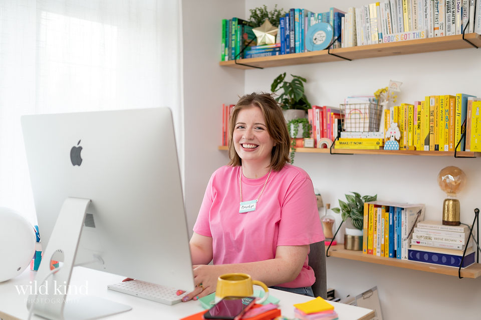 London marketer on apple desktop computer in pink shirt.