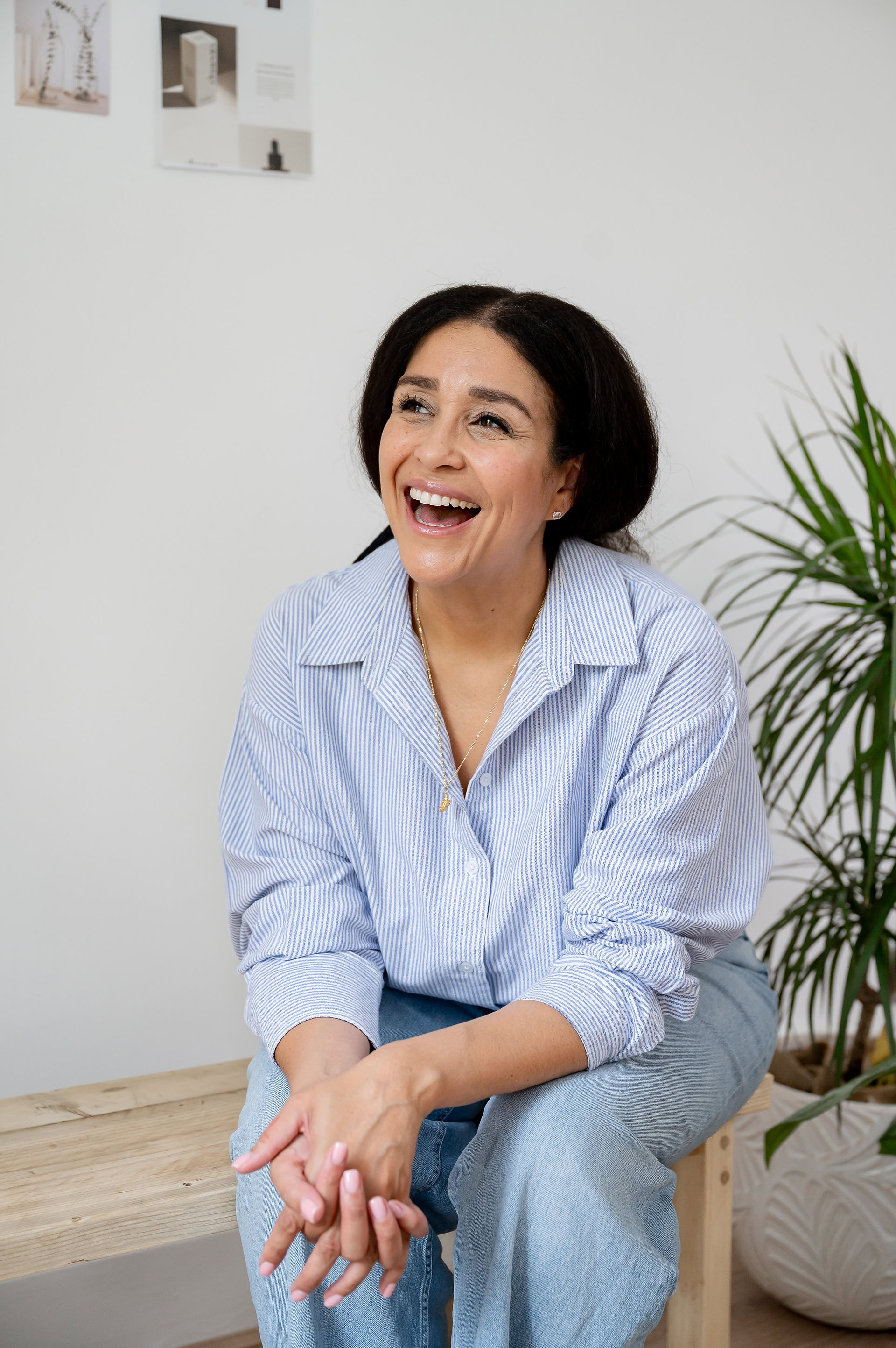 Abeni Lane founder laughing while seated on a bench during her founder lifestyle photoshoot.
