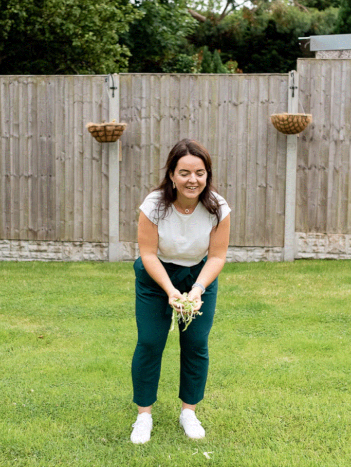 GIF of Functional medicine expert celebrating in garden with arms up during Liverpool brand shoot.