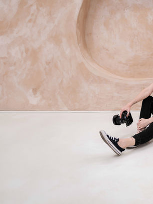Photographer in Liverpool studio sat on floor with camera in hand.