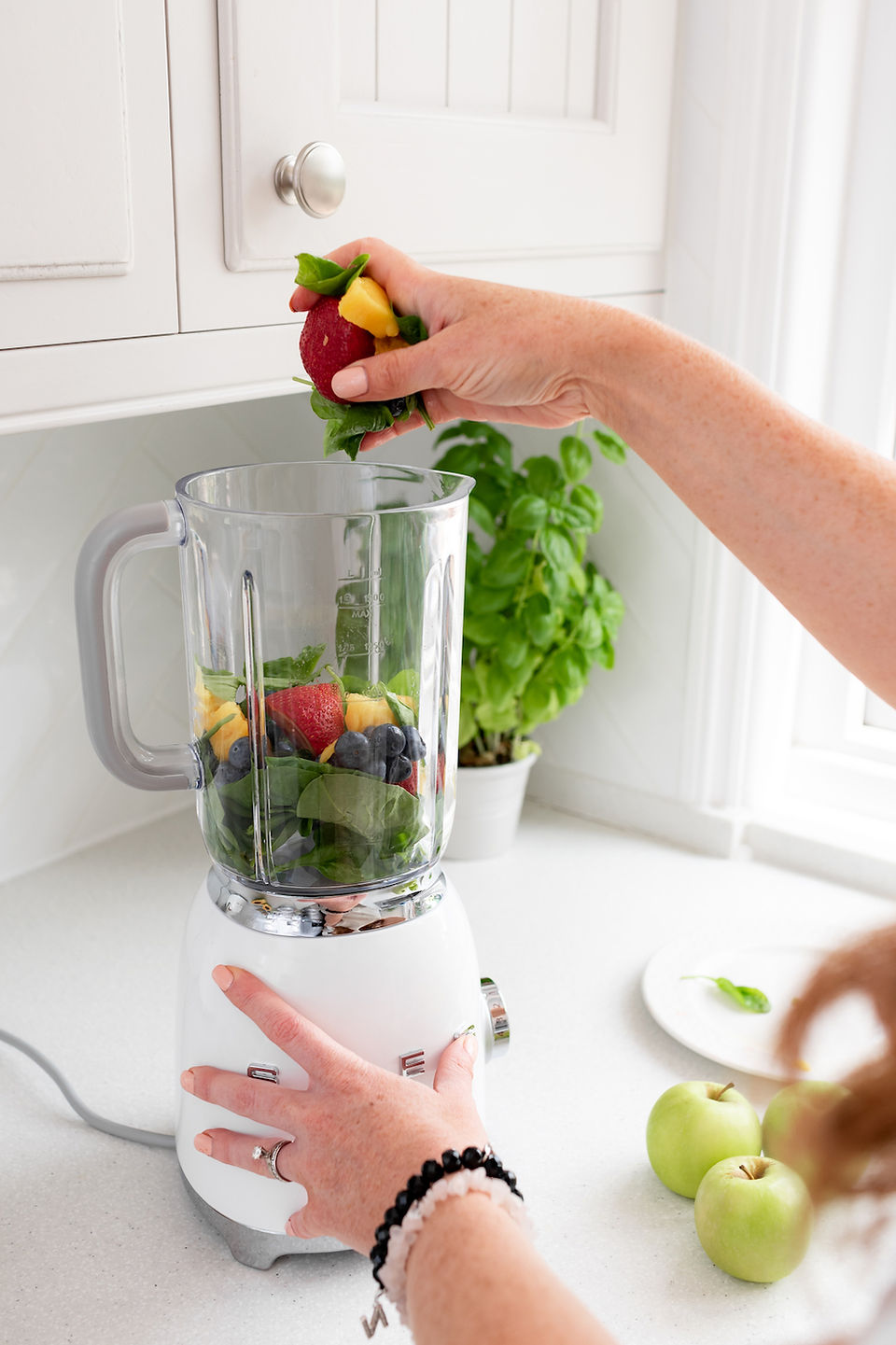 Blending fruit smoothie during health and wellness brand shoot.