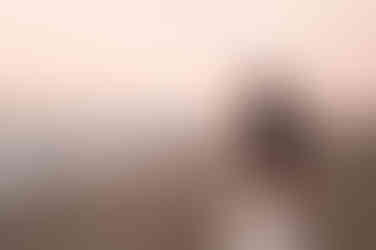 Hypnotherapist burning sage in white dress at Ainsdale Beach.