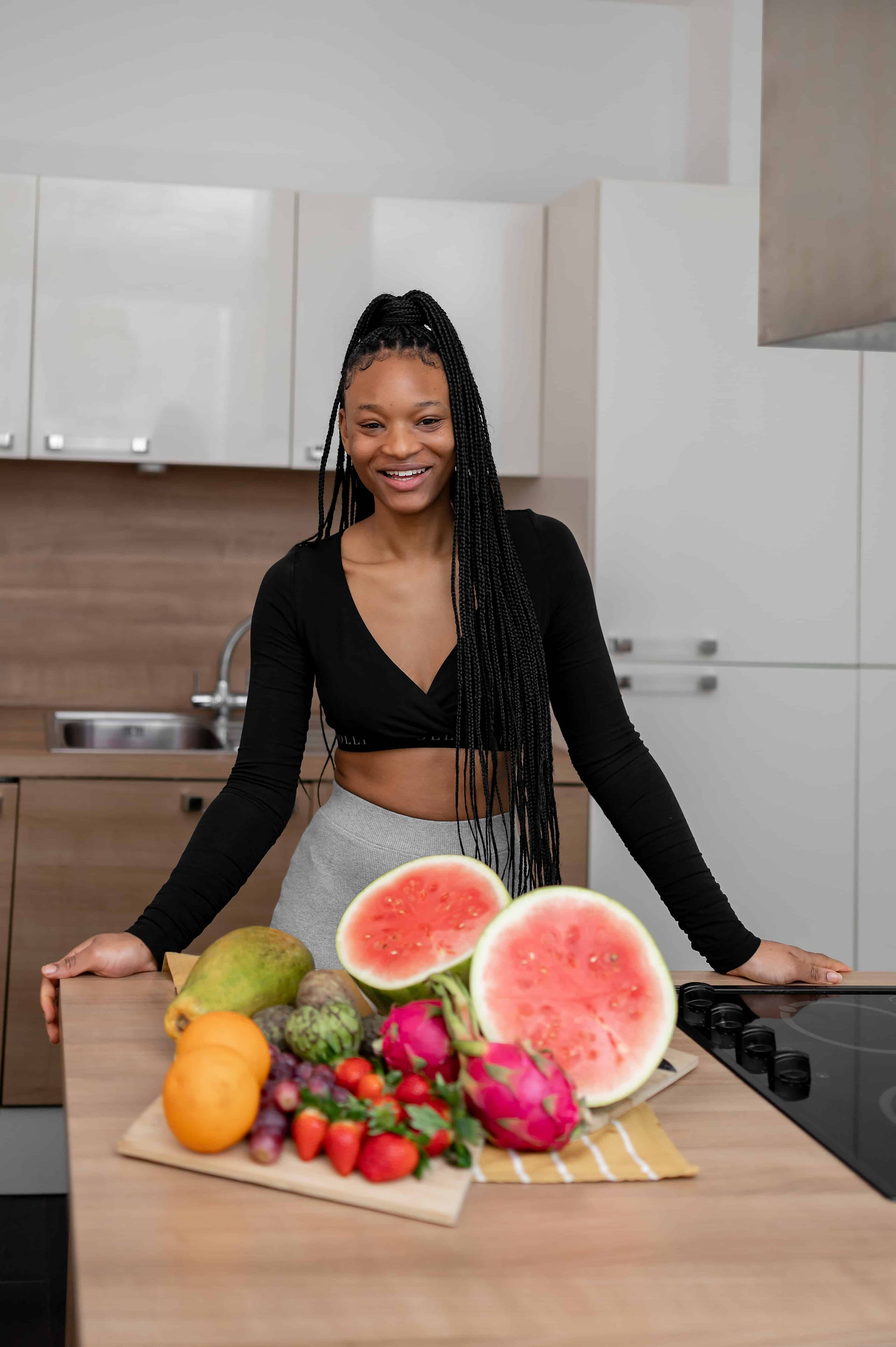 Bright, energetic brand photo in a London studio kitchen rental, featuring a woman surrounded by colorful fruit during a health-focused photoshoot.
