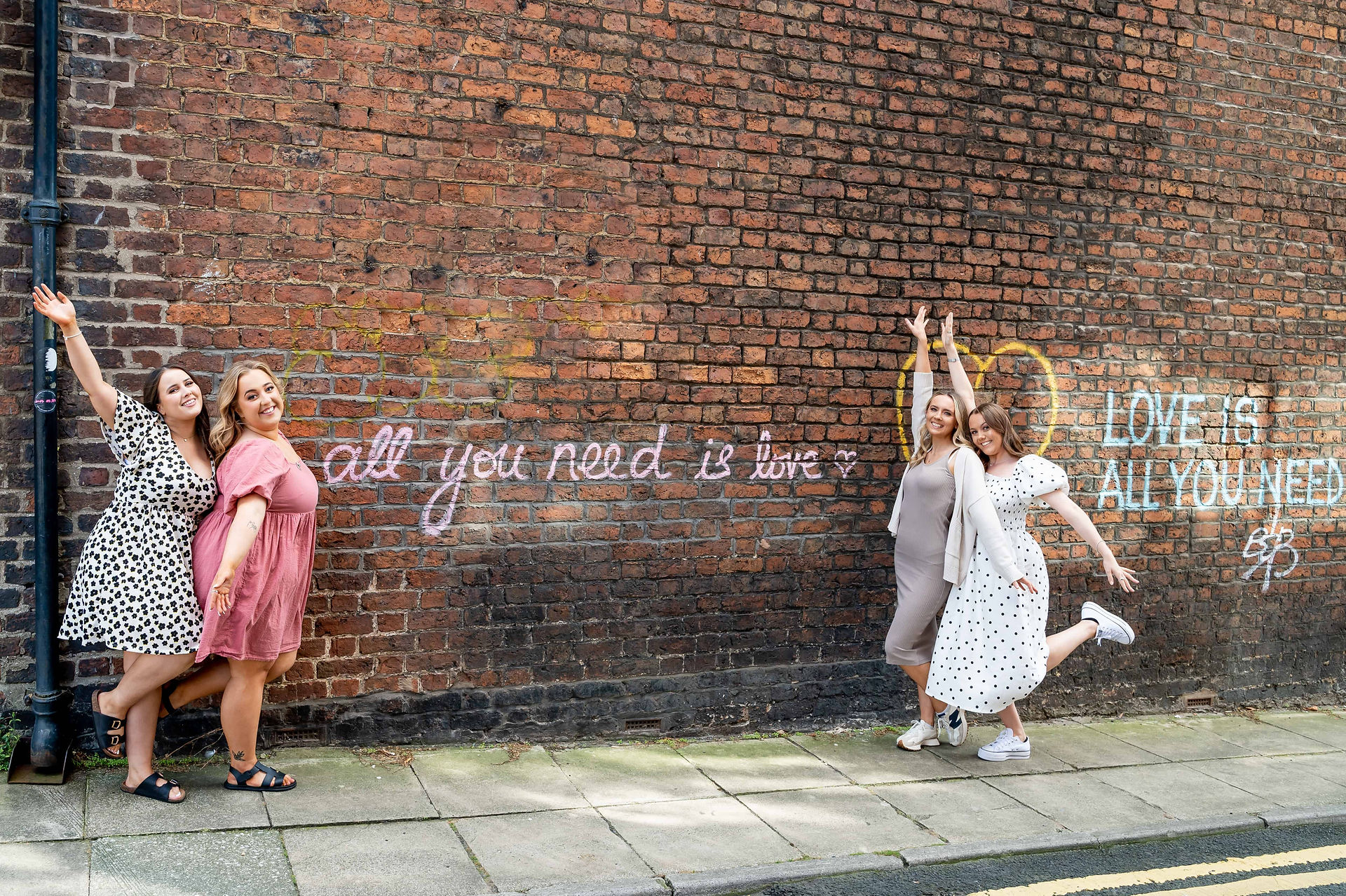 Olivia Hanlon and Girls in Marketing team in front of Liverpool's 'all you need is love' street art.