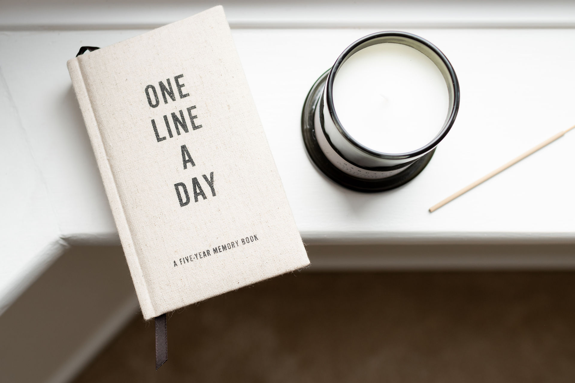 Flatlay of candle and journal used during wellness brand shoot.