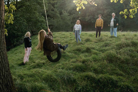 Woman on tire swing in the Peak District at wellness retreat.