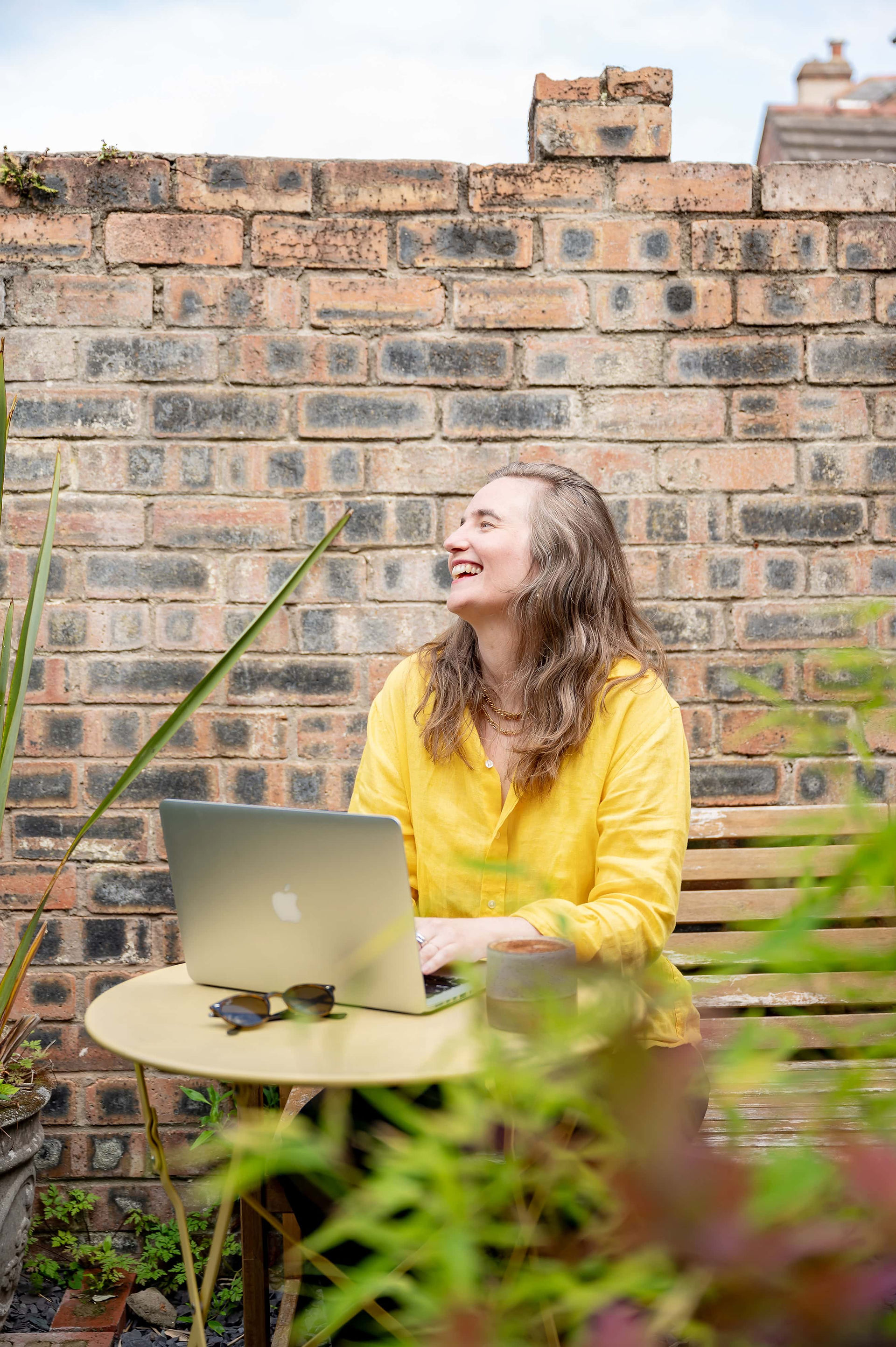 Therapist sat outside in cafe in front of a brick wall in New Brighton.