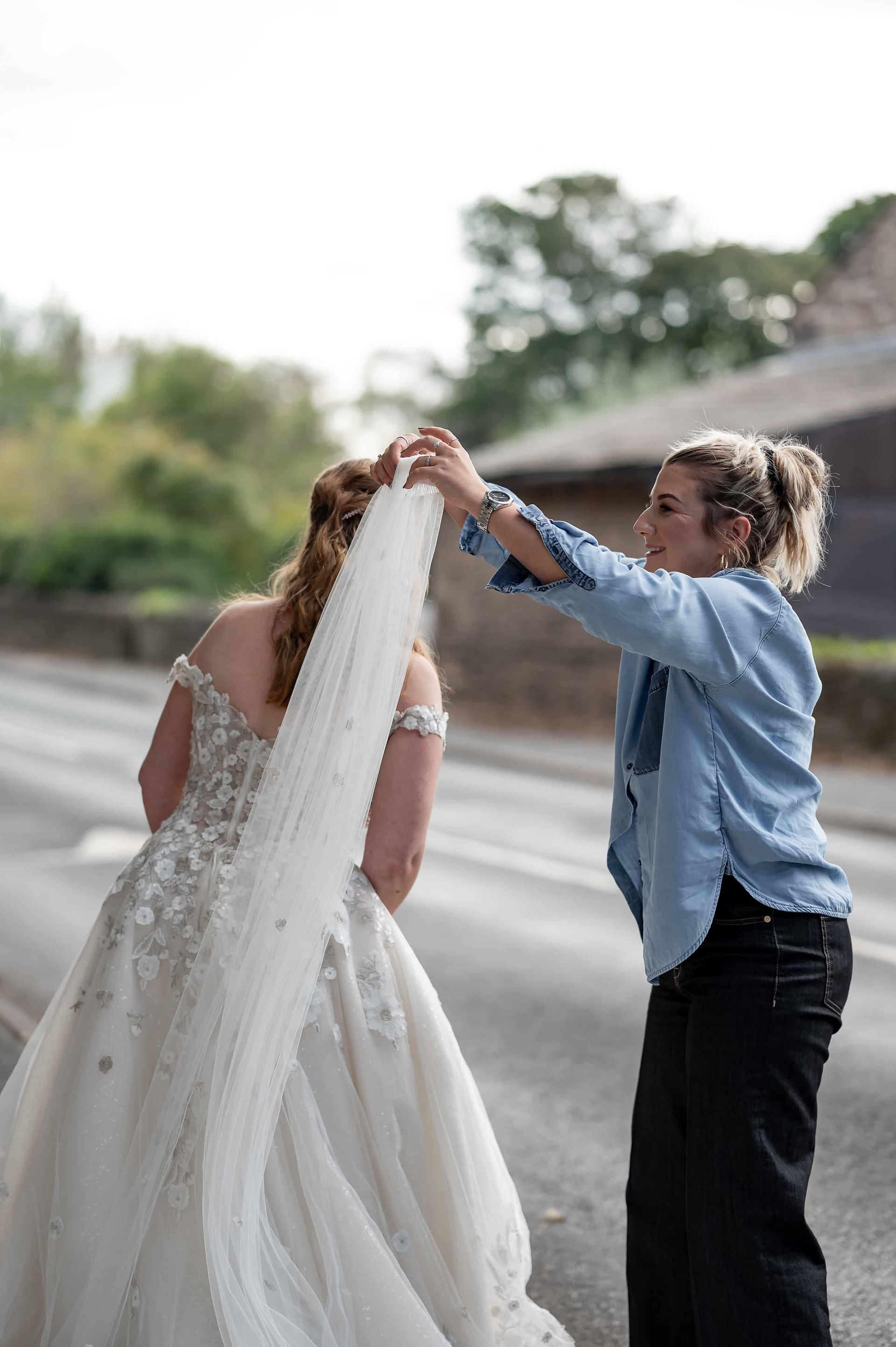 Claire adjusting a flowing bridal veil outdoors during a Liverpool wedding dress photoshoot.