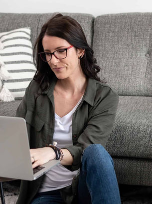 Photographer sat on floor with laptop on coffee table