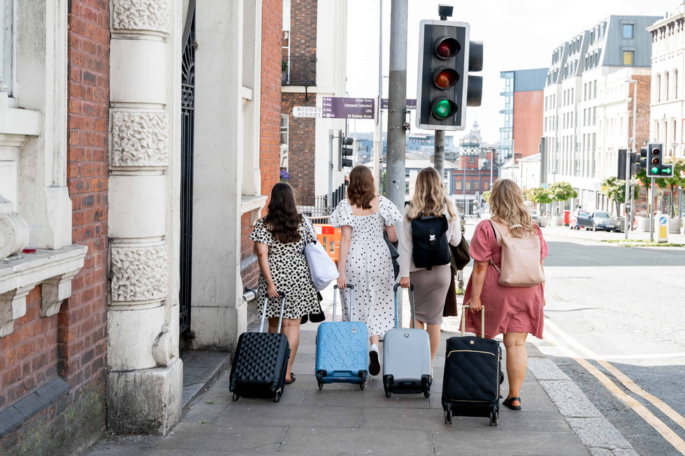 Olivia Hanlon and Girls in Marketing team rolling suitcases through Liverpool.