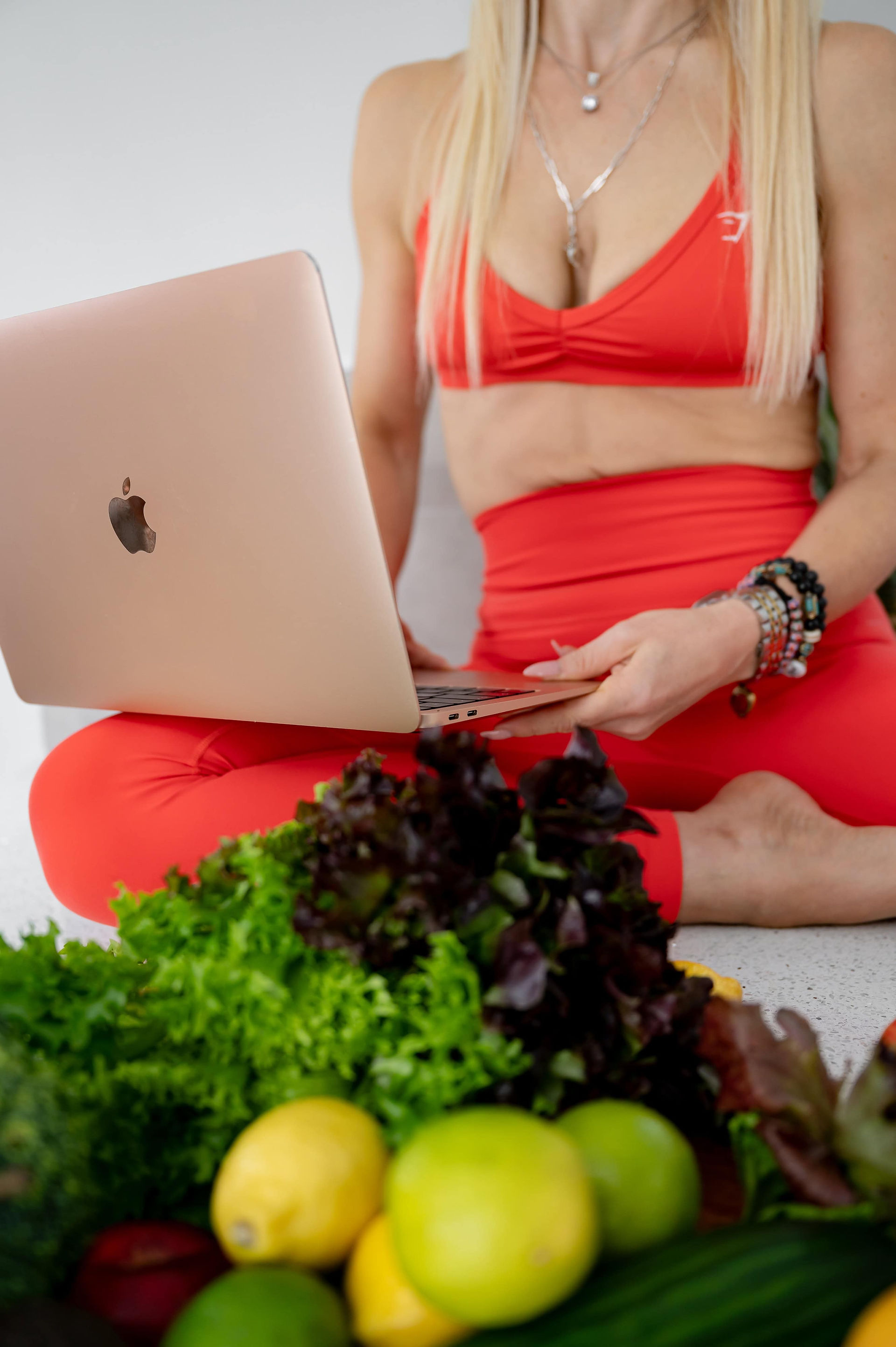 Pilates instructor and nutrition coach Holistically Balanced Blonde working on a laptop surrounded by fresh greens during a North Wales brand photoshoot.
