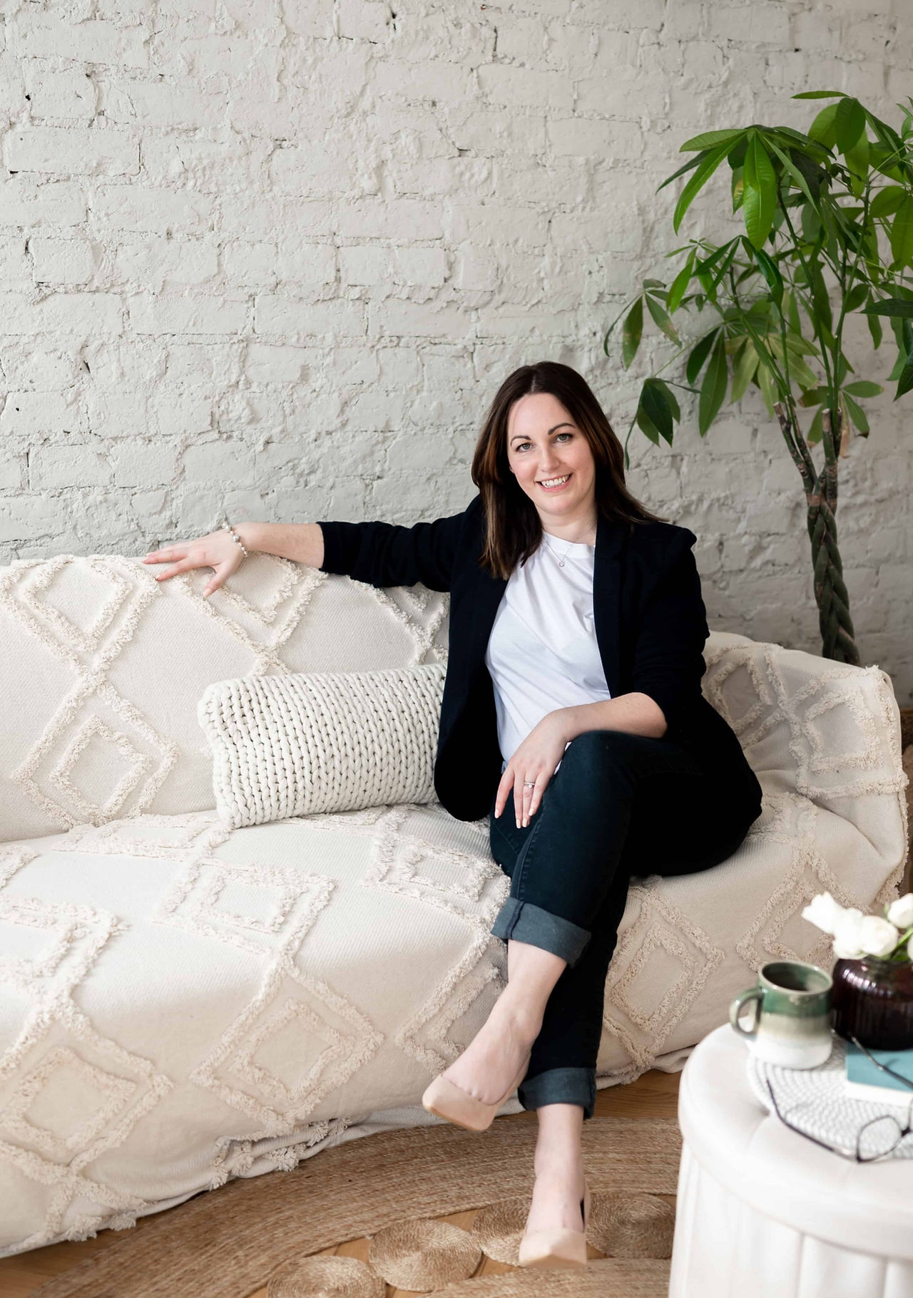 Woman sat on couch with legs crossed.