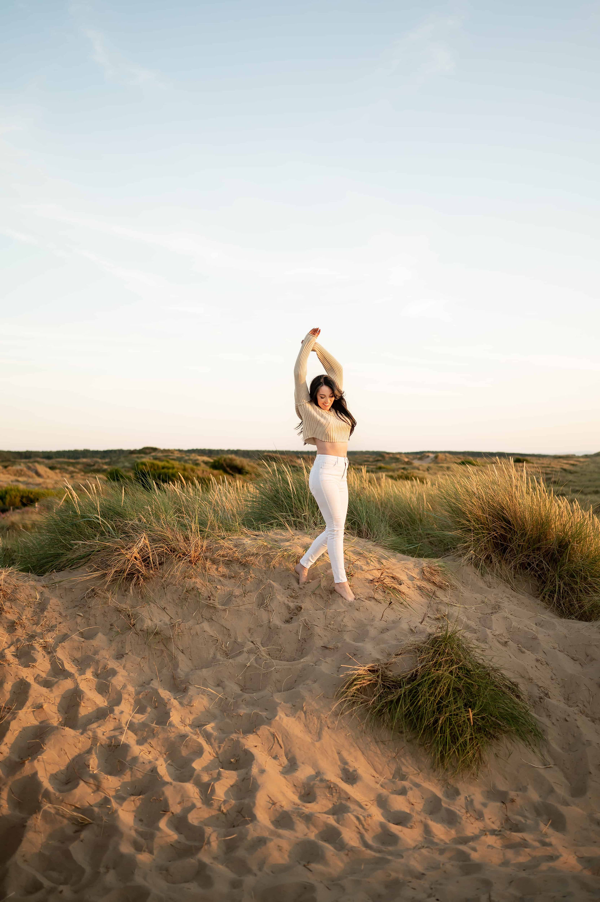 Hypnotherapist dancing in dunes at Ainsdale Beach.
