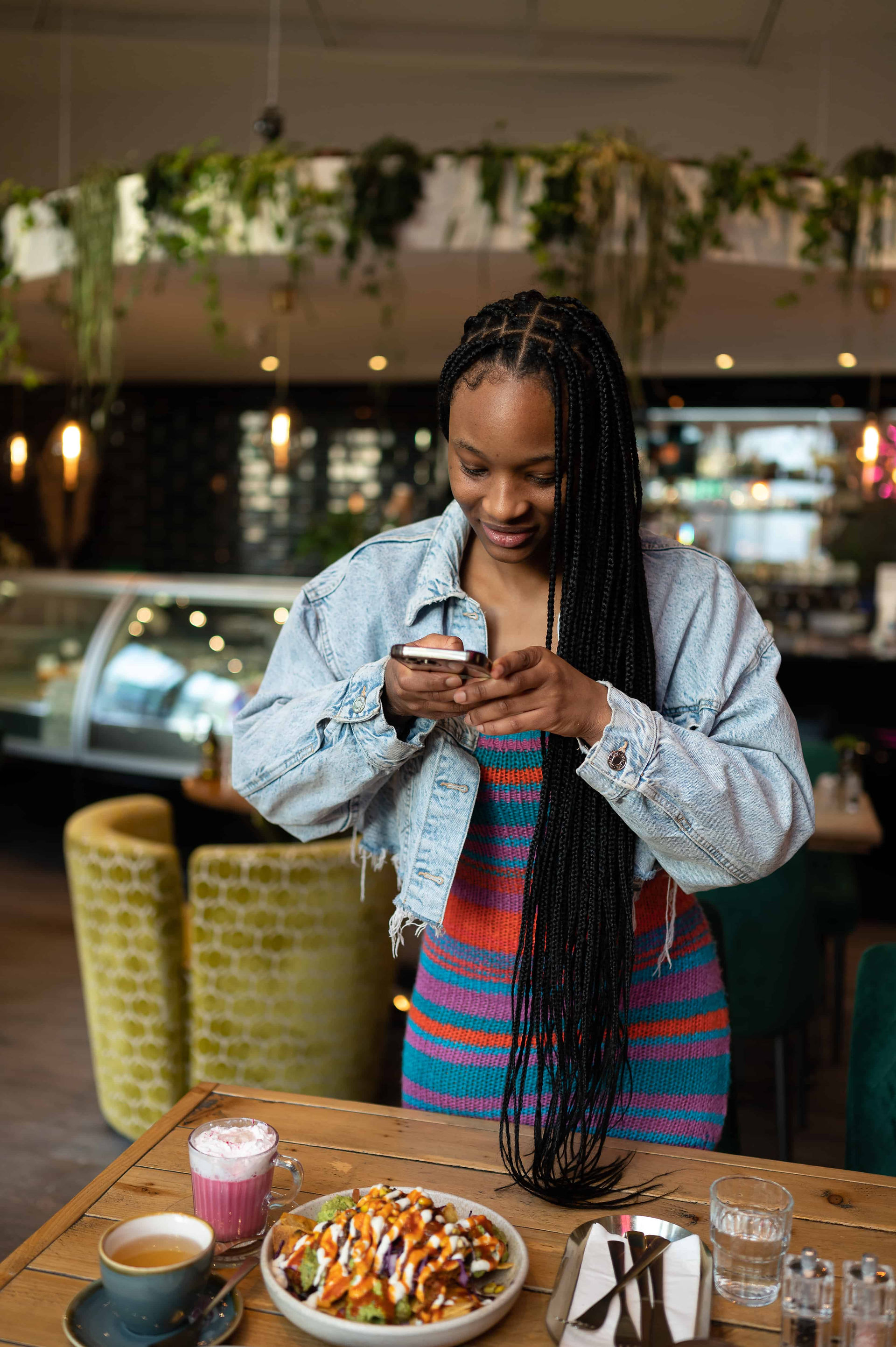 Vegan business owner taking overhead photos of plantbased meal at the Vibe Cafe in Liverpool.
