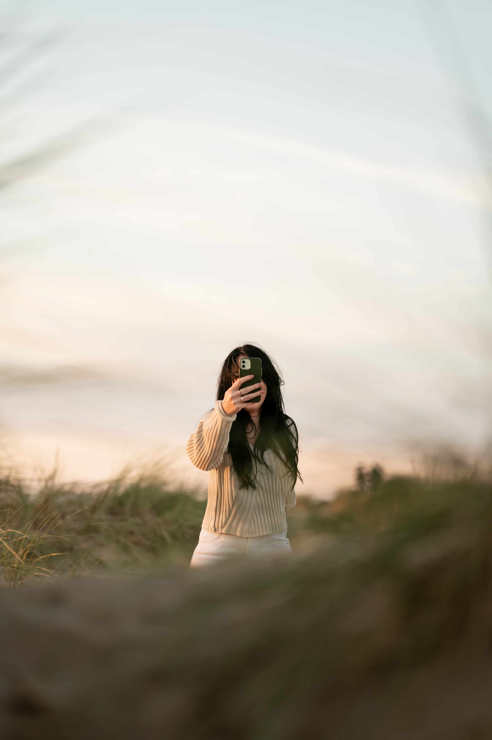 Hypnotherapist taking a phone photo in dunes at Ainsdale Beach.