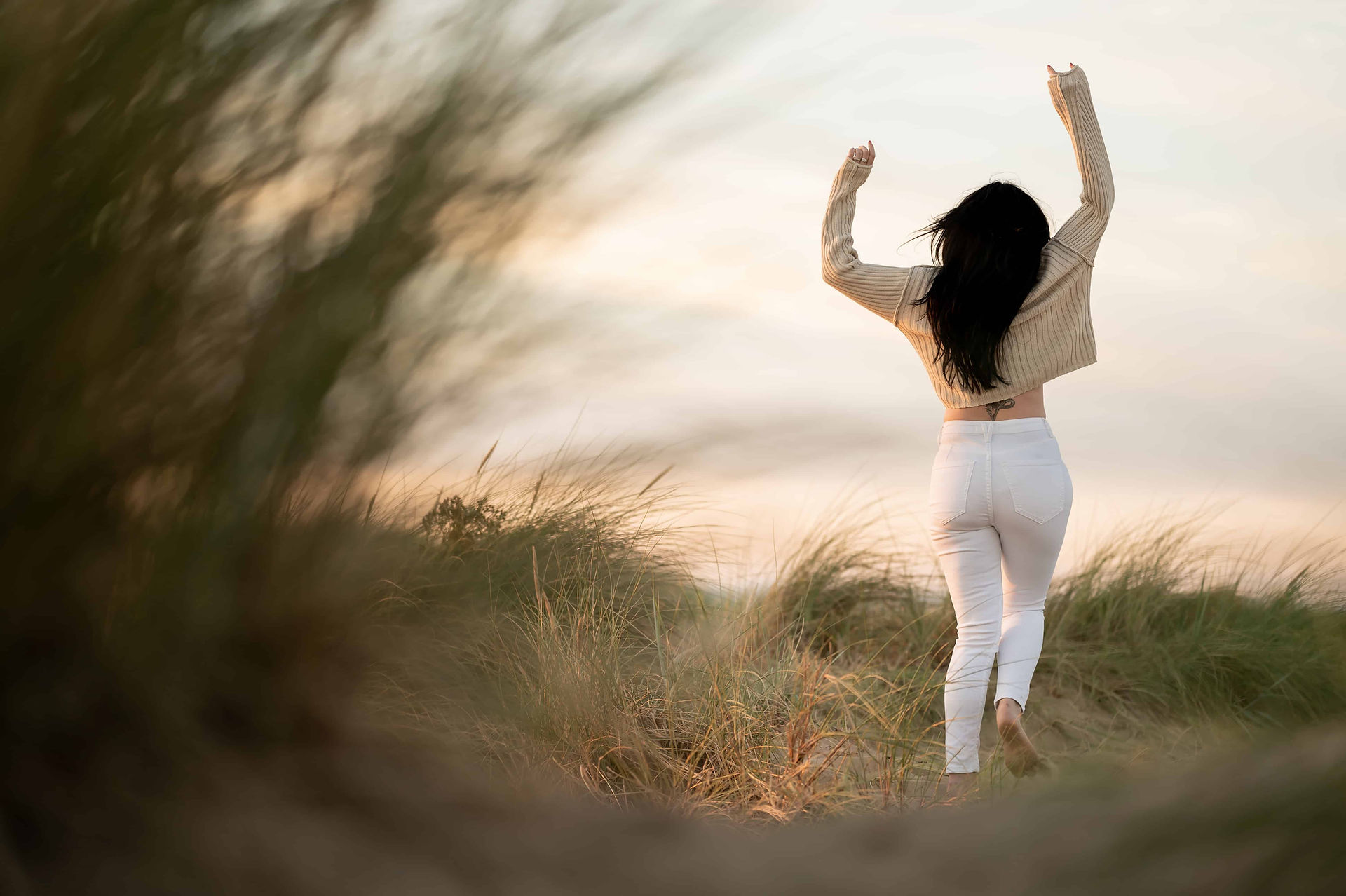Hypnotherapist dancing in dunes at Ainsdale Beach.