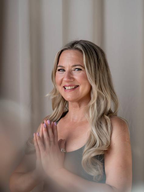 Studio portrait of Emily smiling with hands together in gratitude pose
