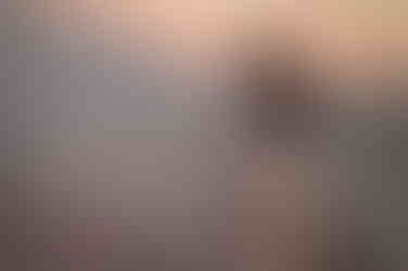 Hypnotherapist wading in water in white dress at Ainsdale Beach with sage.