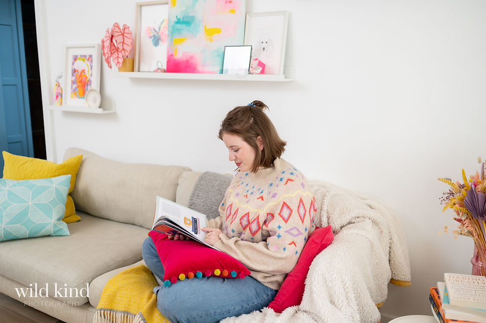 London marketer reading on couch.