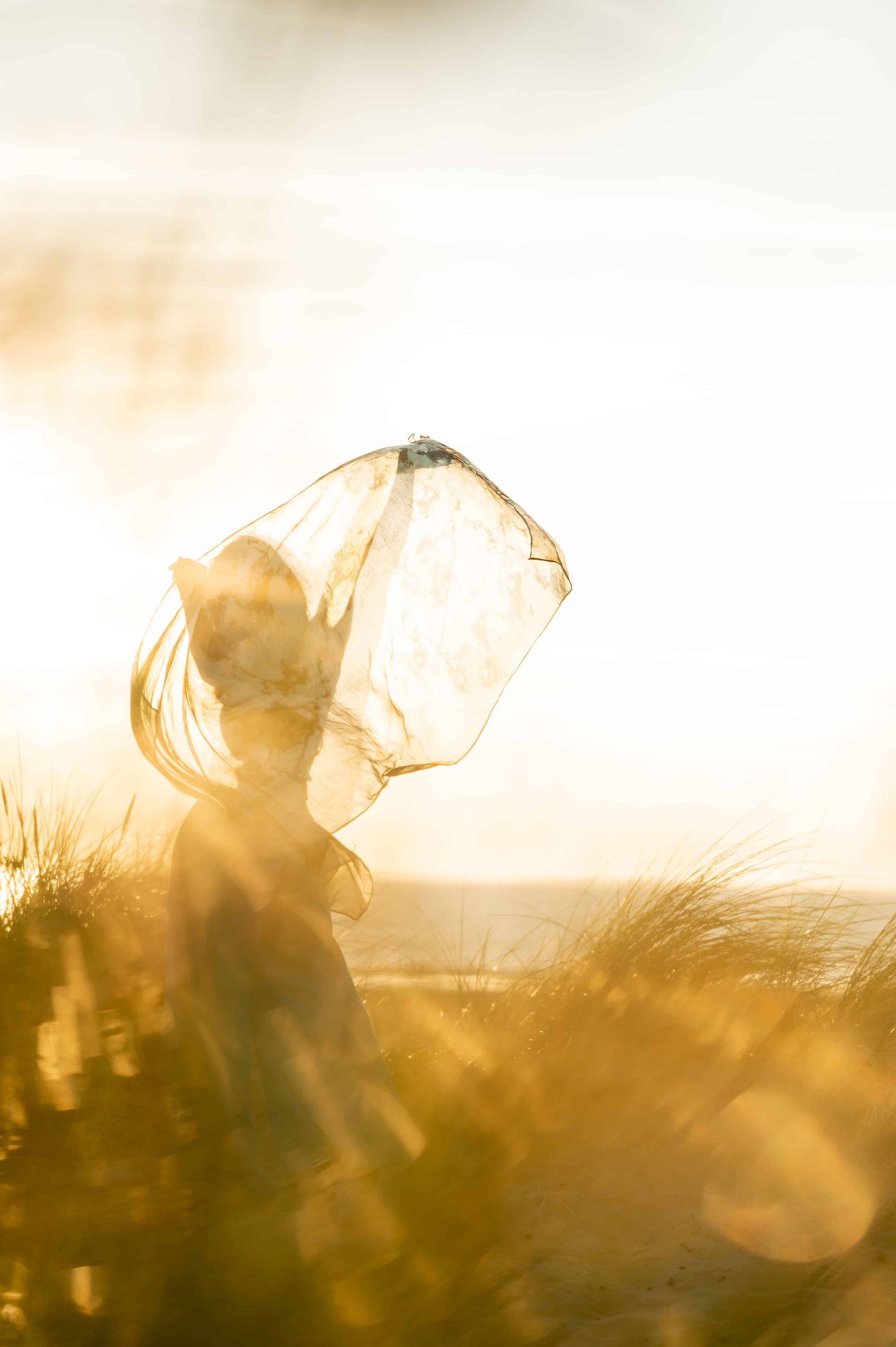 Hypnotherapist dancing with scarf at Ainsdale Beach during sunset.