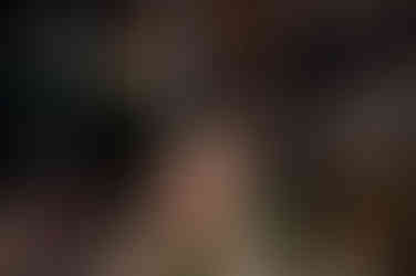 Rachael Does Design eats croissant and laughs outside a modern industrial café space.