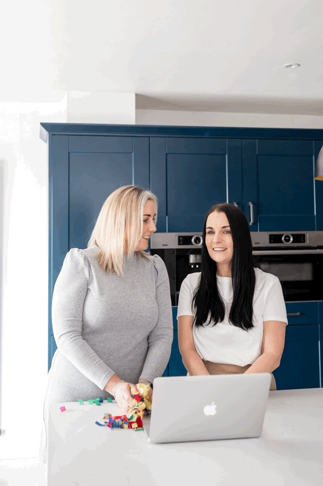 Gif of 2 women throwing colorful confetti in the air in a bright and airy kitchen.