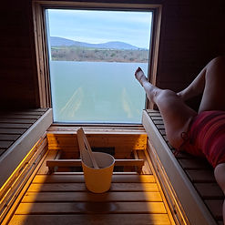 Legs in a sauna looking out at a lake