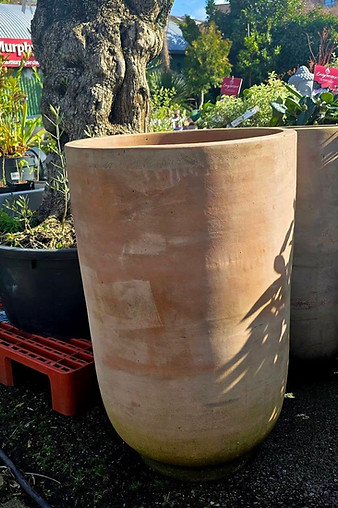Large terracotta cylindrical ceramic pot outdoors