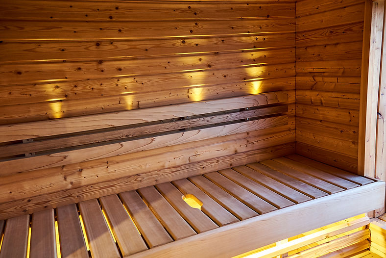 Wooden sauna interior with benches and warm lighting