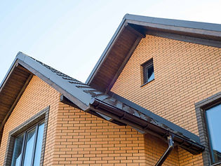 Brick house roof with dark gutters