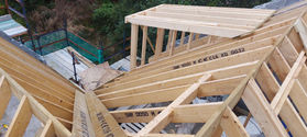 Roof construction progress showing wooden rafters