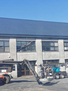 Building with construction equipment in front of the structure.