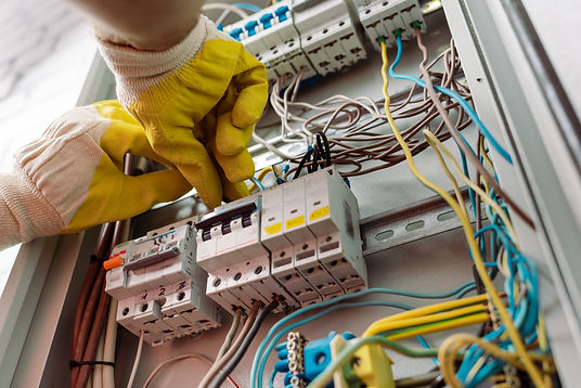 low-angle-view-of-electrician-in-gloves-fixing-ele-HE75HSX.jpg