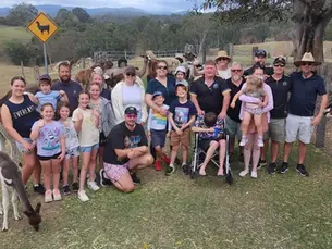 The Veterans Gaming community taking a photo infront of a Llama.