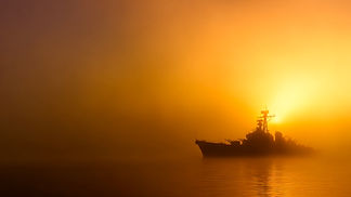 vecteezy_silhouette-of-a-wwii-military-ship-against-a-foggy-sunset_70484497.jpg