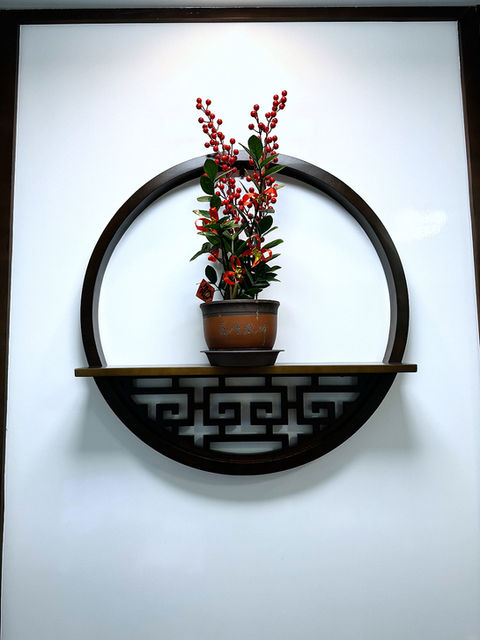 Round wall decor at Better Wellness TCM with traditional flower pot symbolizing energy